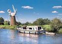 Boat and windmill on River Bure in Norfolk Broads